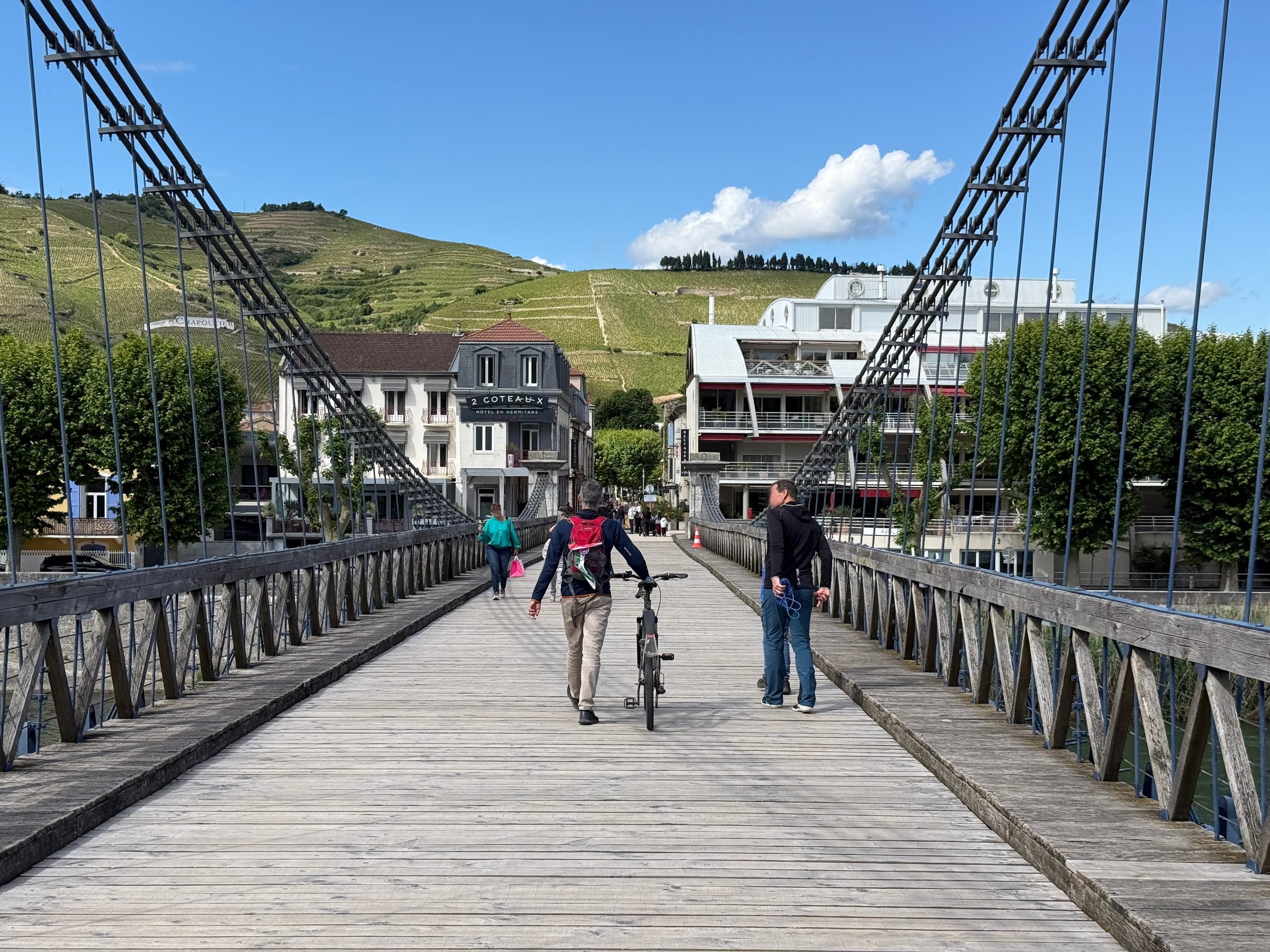 La passerelle Marc Seguin en bois entre Tournon-sur-Rhône et Tain-l'Hermitage, coteaux de l'Hermitage au fond