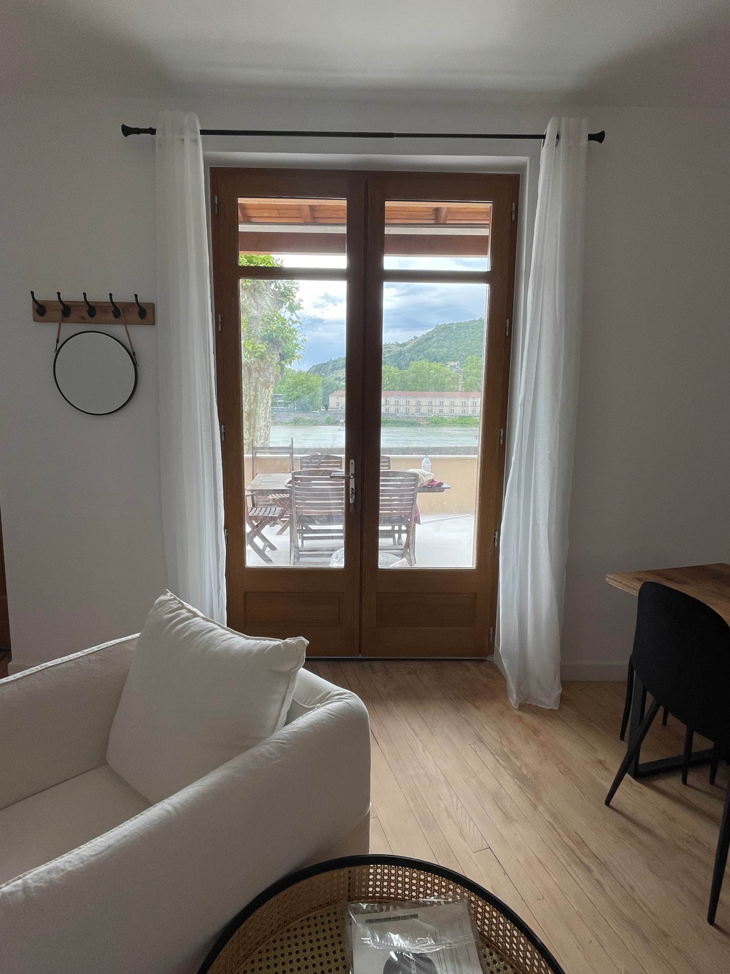 Porte-fenêtre en bois du séjour donnant sur la terrasse et le Rhône
