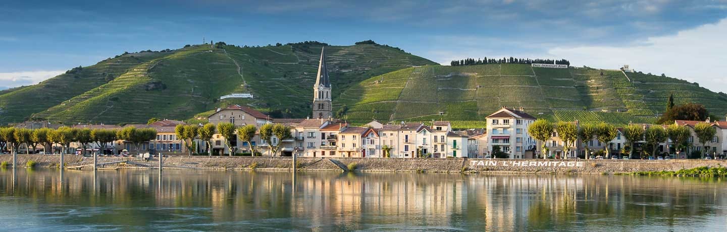 Tain-l'Hermitage vue depuis le Rhône : les quais, le clocher et la colline de l'Hermitage plantée de vignes