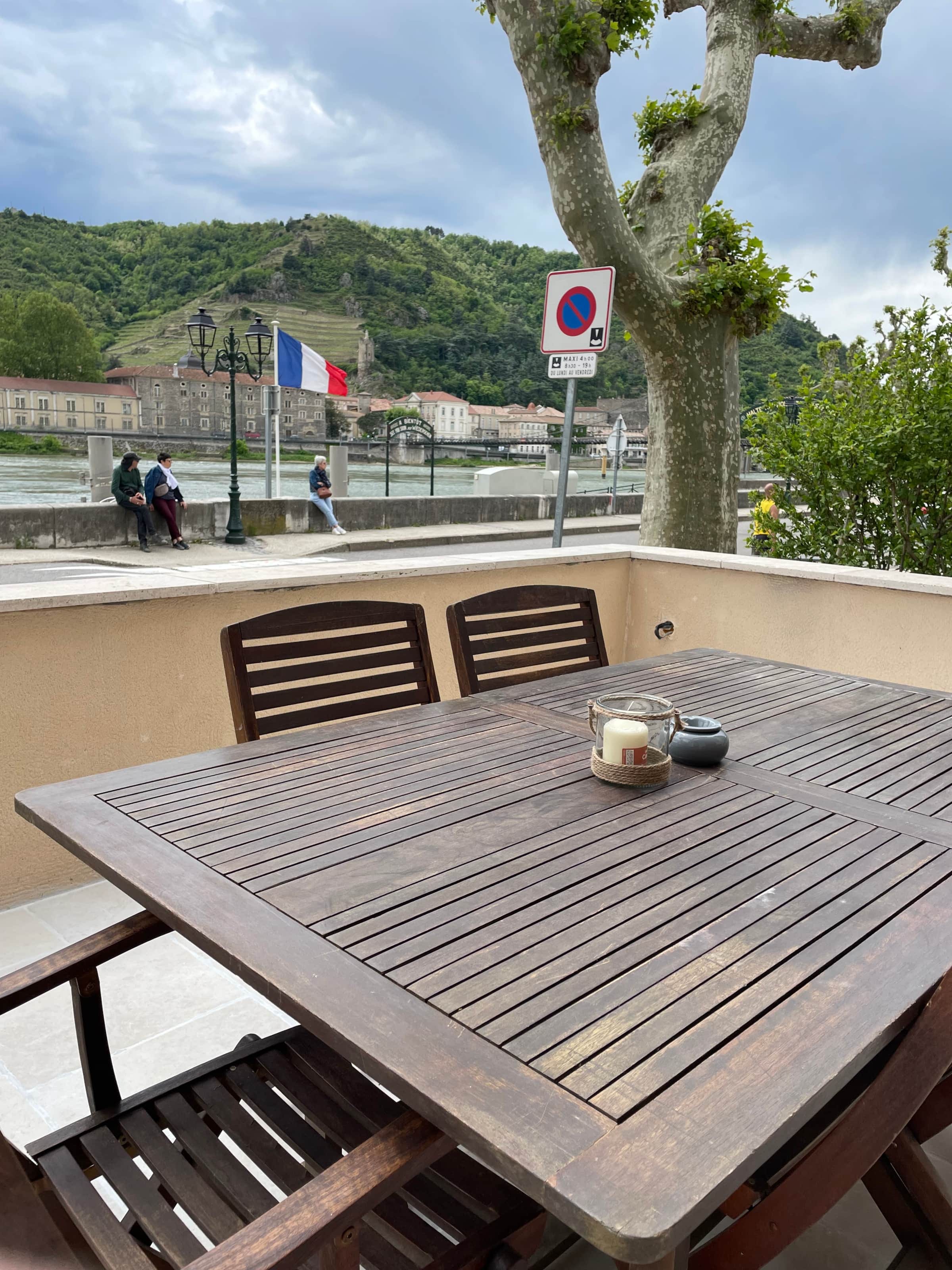 Table de la terrasse avec bougie, vue sur le quai, le Rhône et la colline de l'Hermitage